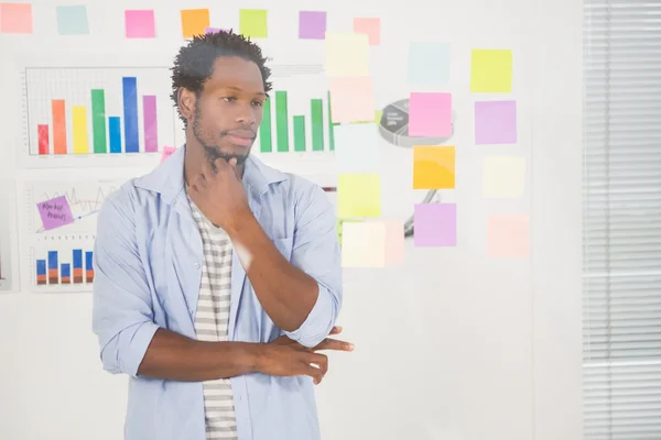 Schöner Gelegenheitsunternehmer mit Blick auf Post-it — Stockfoto