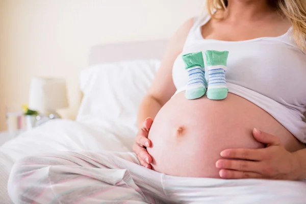 Bebek Patiği yumru üzerinde olan hamile kadın — Stok fotoğraf