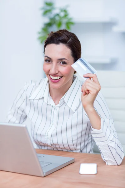 Pretty brunette businesswoman using her credit card — Stock Photo, Image