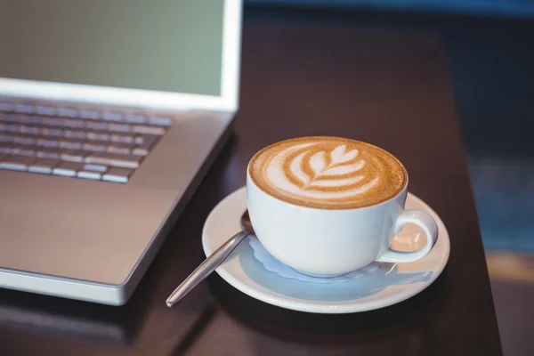 Laptop en koffie op tafel — Stockfoto