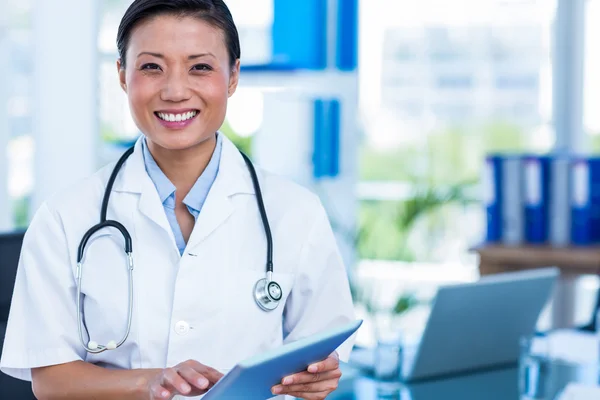 Feliz médico sonriendo a la cámara sosteniendo la tableta —  Fotos de Stock