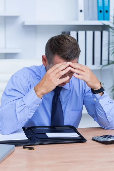 Businessman with severe headache sitting at office desk — Stock Photo, Image