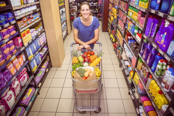 Bella donna spingendo carrello in corridoio — Foto Stock