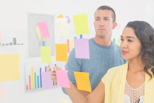 Concentrated coworkers pointing sticky notes — Stock Photo, Image