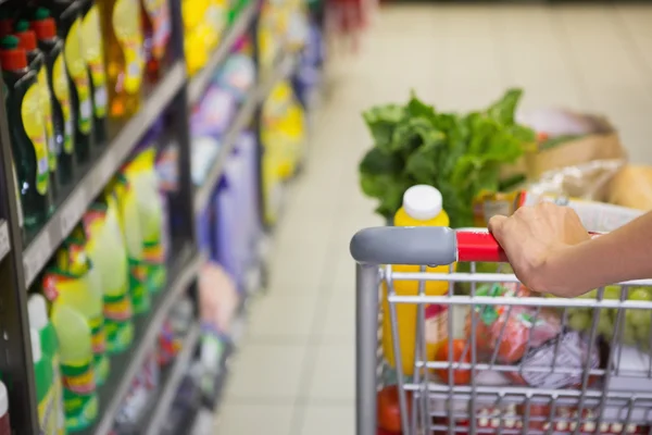 Vrouw kopen producten met haar trolley — Stockfoto