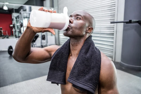 Joven culturista bebiendo una botella de agua después del entrenamiento — Foto de Stock