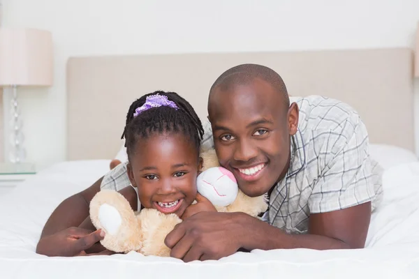 Söt liten flicka med sin far i sängen — Stockfoto
