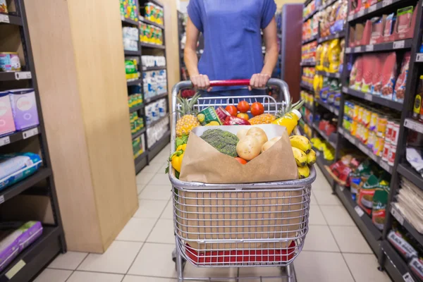 Vrouw duwen trolley koffer in gangpad — Stockfoto