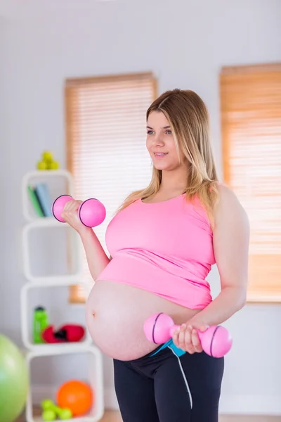 Une femme enceinte tenant des haltères — Photo