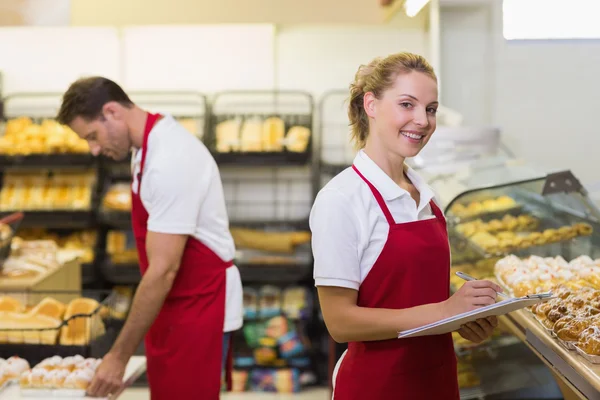 Portrait of a blonde baker with her colleague — Stock Photo, Image