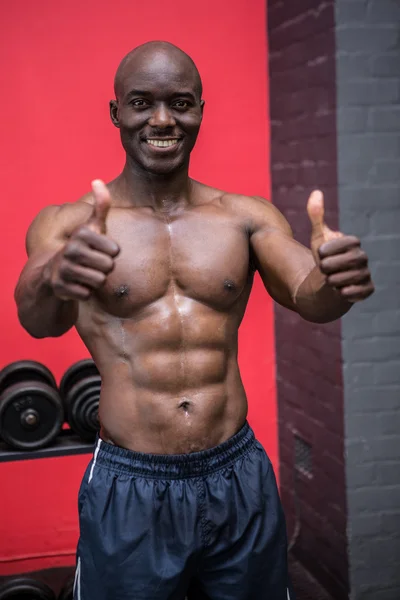 Young Bodybuilder standing in front of the camera with his thumb — Stock Photo, Image