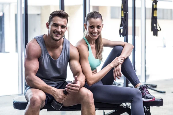 Sonriente pareja muscular sentada en el banco —  Fotos de Stock