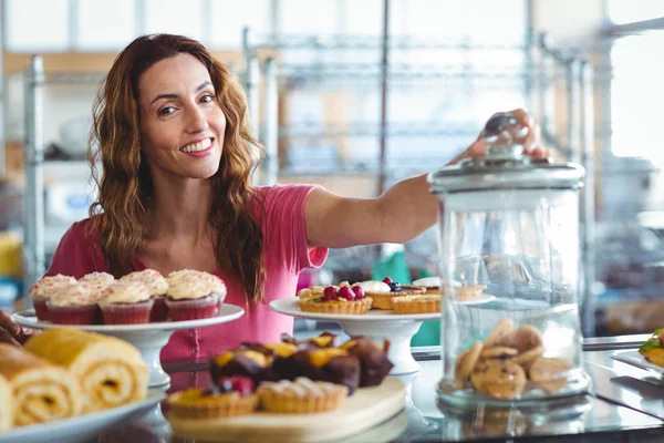 Brunette behind plates of pastries — Stock Photo, Image