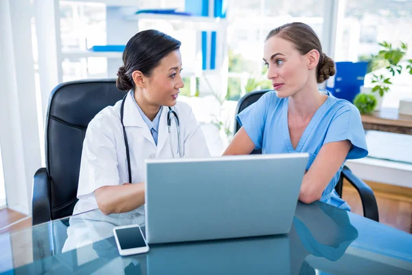 Doctor y enfermera mirando el ordenador portátil — Foto de Stock