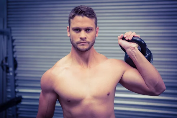 Retrato del hombre musculoso levantando una kettlebell —  Fotos de Stock