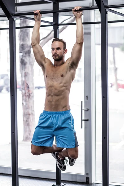 Homem muscular fazendo puxar para cima exercícios — Fotografia de Stock