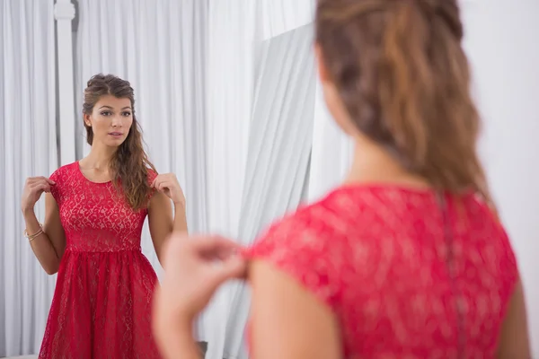 Femme essayant une robe rouge — Photo