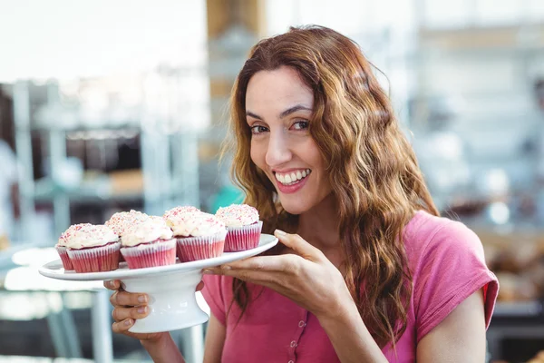 Brunette holding plate of pastries — Stock Photo, Image