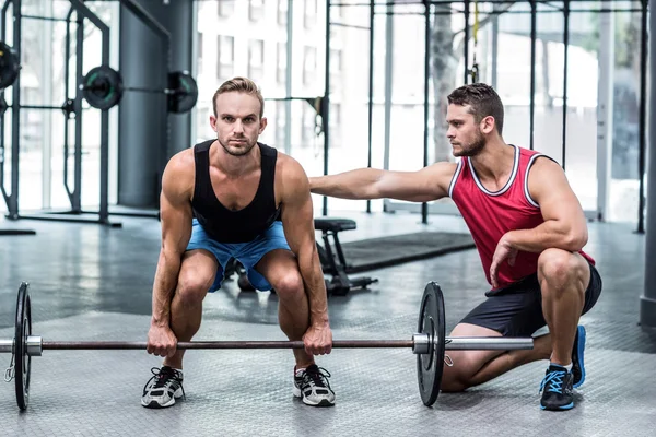 Uomo muscolare che solleva un bilanciere — Foto Stock