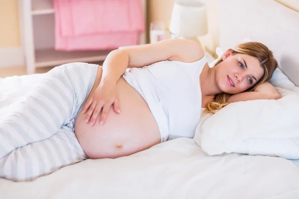 Pregnant woman lying on bed — Stock Photo, Image