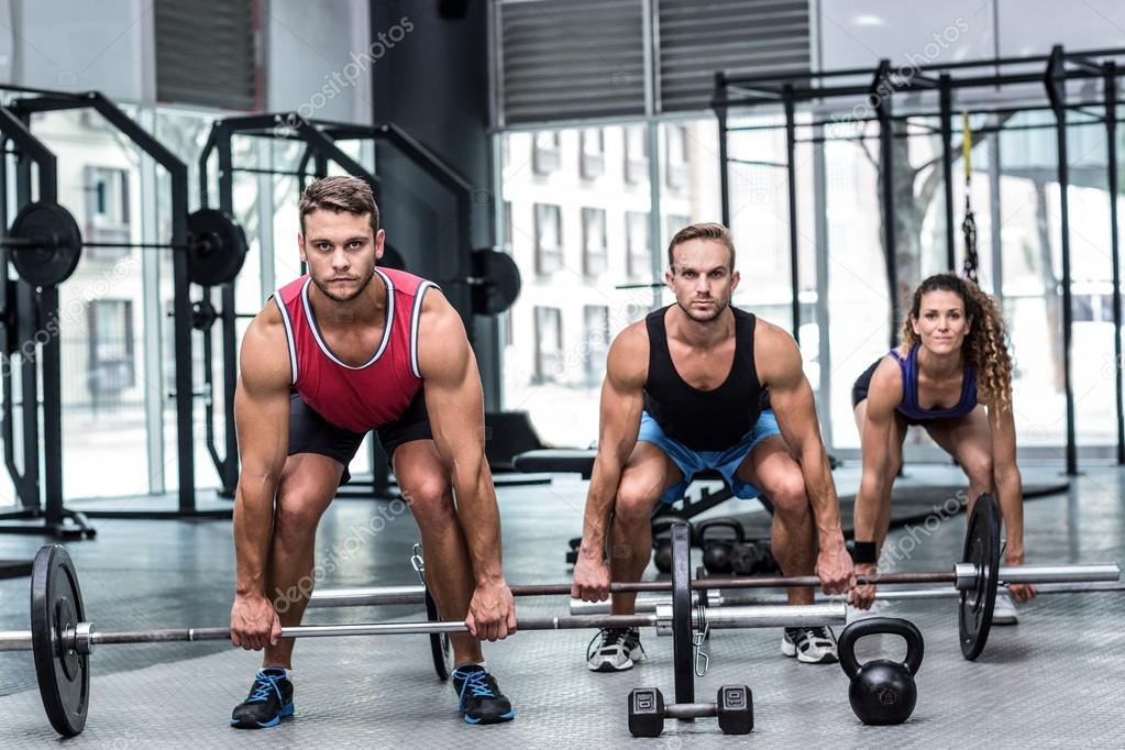 Muscular athletes lifting a barbell — Stock Photo © Wavebreakmedia