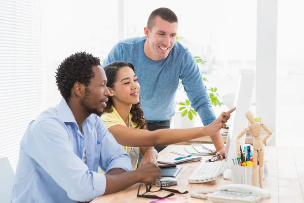 Sorrindo colegas de trabalho usando o computador juntos e apontando o scree — Fotografia de Stock