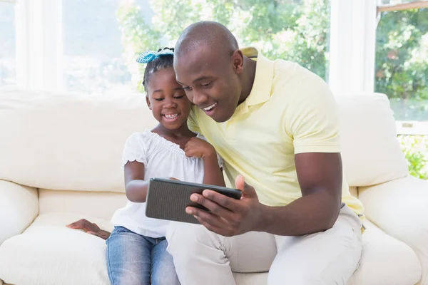 Feliz padre sonriente usando tableta digital con su hija en c — Foto de Stock