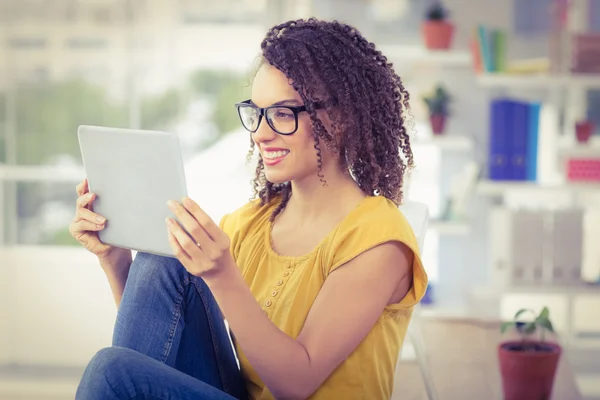 Souriant jeune femme d'affaires regardant sa tablette — Photo