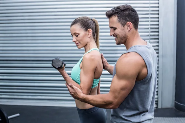 A muscular woman lifting dumbbells — Stock Photo, Image