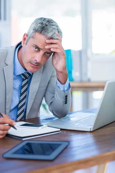 Depressed businessman trying to work — Stock Photo, Image