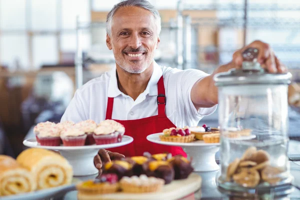 Heureuse barista derrière des assiettes de gâteaux — Photo