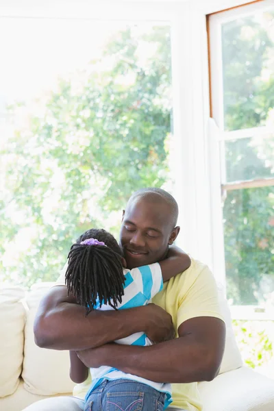 Šťastný otec usmívající se obejmout se svou dcerou v gauči — Stock fotografie