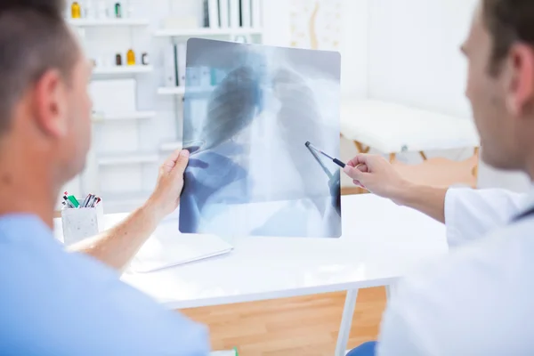 Rear view of concentrated medical colleagues examining x-ray — Stock Photo, Image