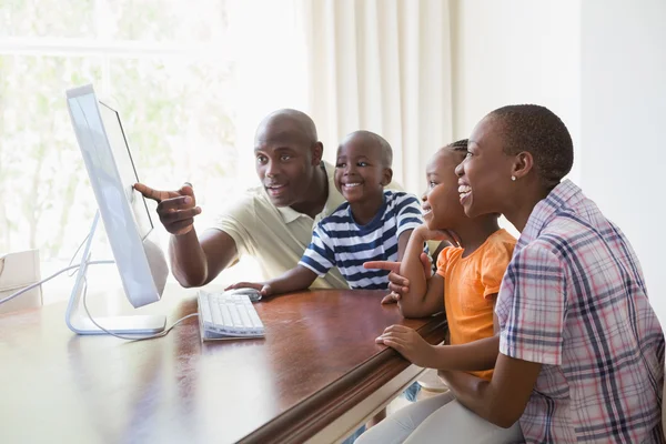 Feliz família sorrindo usando o computador — Fotografia de Stock