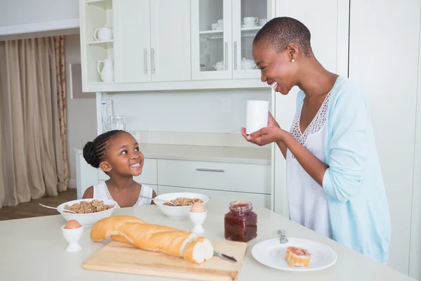 Sorrindo mãe e filha comendo juntos — Fotografia de Stock