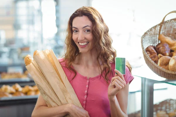Brunett med kreditkort och baguetter — Stockfoto