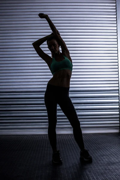 Musculosa mujer estiramiento en sombra habitación —  Fotos de Stock