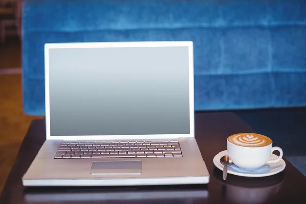 Laptop and coffee on table — Stock Photo, Image