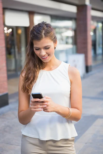 Femme souriante utilisant un smartphone — Photo