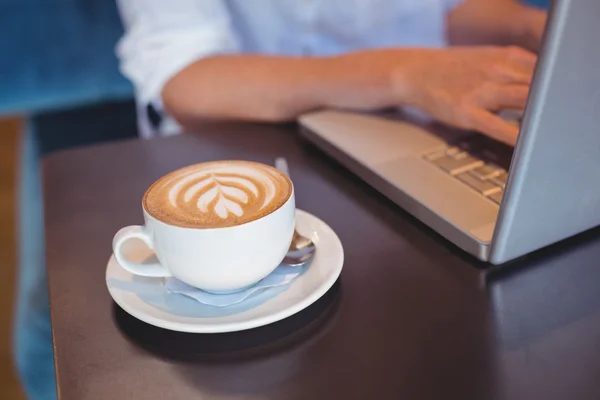 Девушка с кофе с помощью ноутбука — стоковое фото