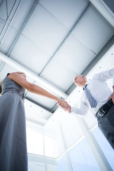 Dos personas sonrientes de negocios dándose la mano — Foto de Stock