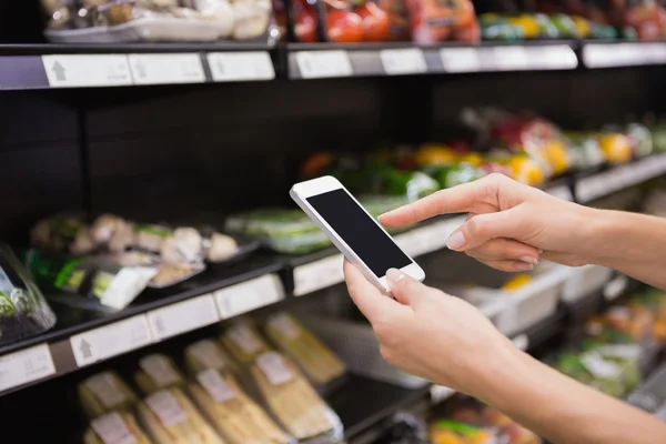 Wanita membeli produk dan menggunakan smartphone-nya — Stok Foto