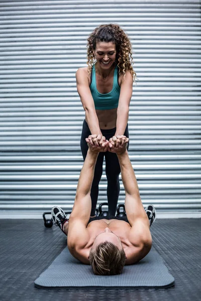 Casal muscular fazendo exercícios principais — Fotografia de Stock