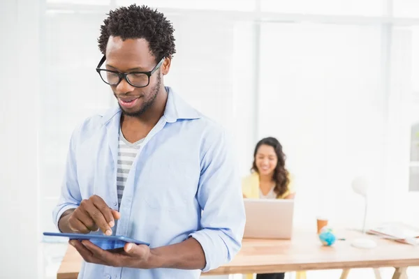 Uomo in posa davanti al suo collega con tablet — Foto Stock