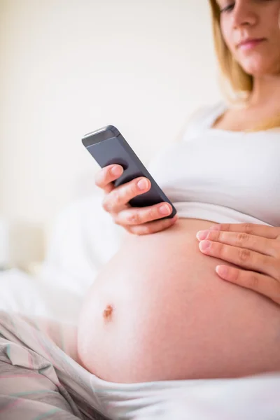 Kobieta w ciąży za pomocą jej smartphone — Zdjęcie stockowe