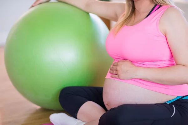 Femme enceinte assise avec ballon d'exercice — Photo