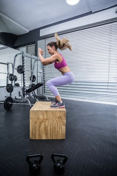 Мускулистая женщина, прыгающая на корточках — стоковое фото