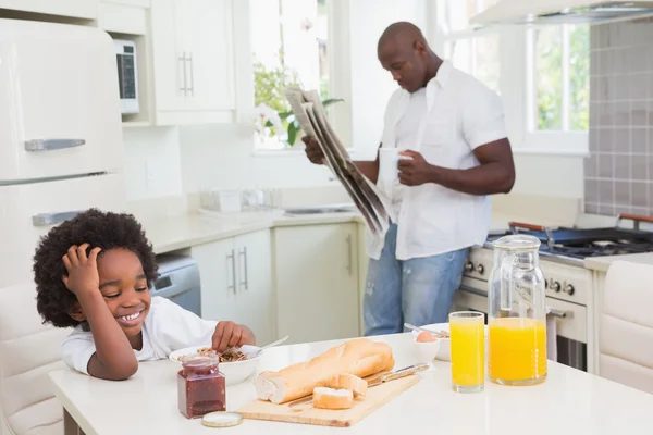 Улыбающиеся отец и сын завтракают — стоковое фото