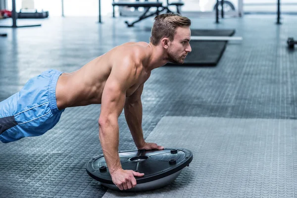 Muskulös man gör bosu boll övningar — Stockfoto