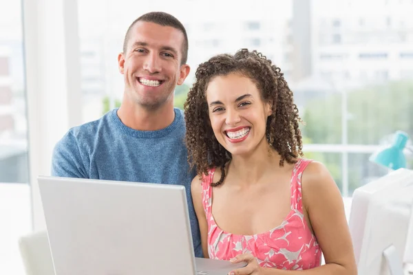 Portrait of creative business colleagues holding a laptop — Stock Photo, Image